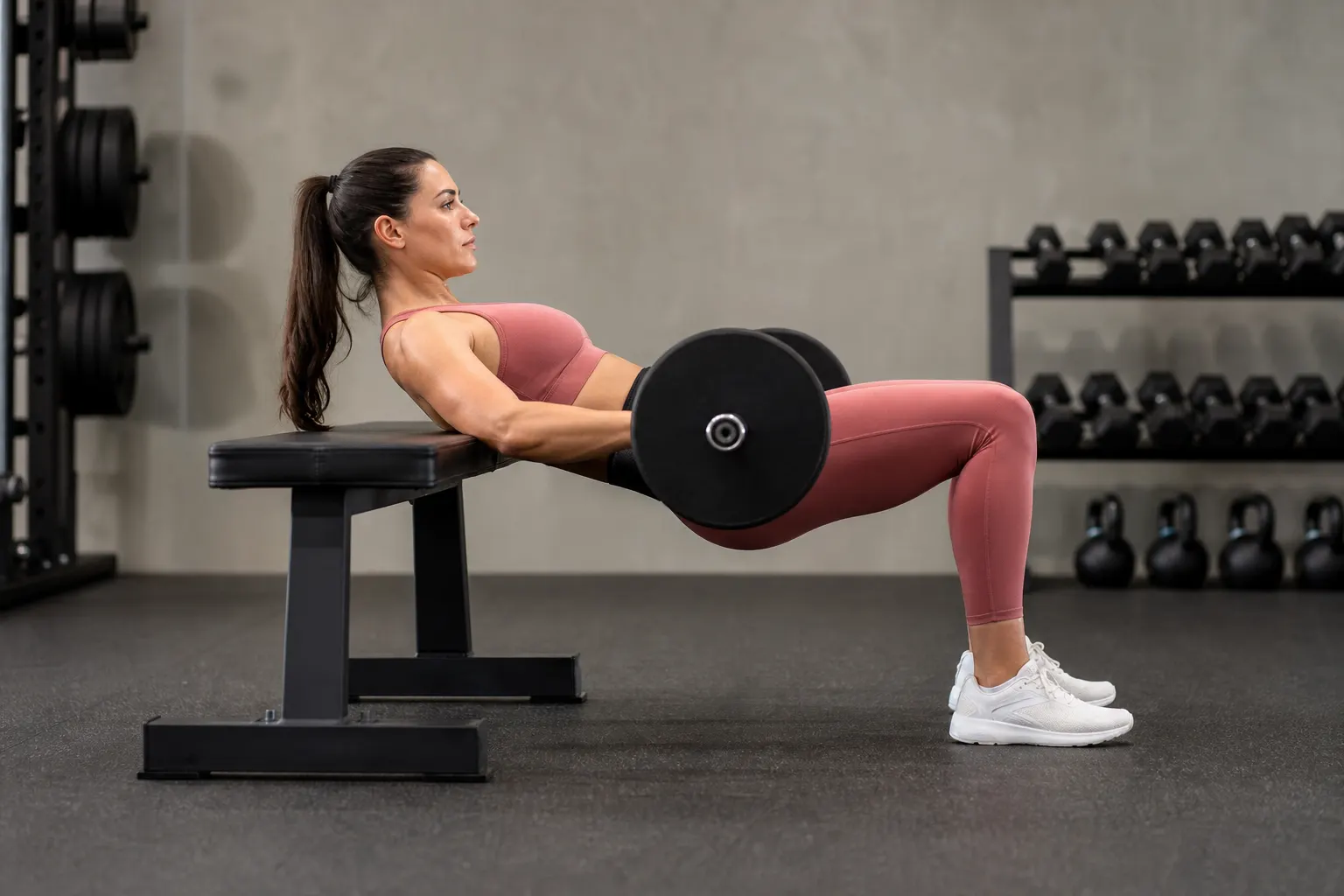 Side view of a barbell hip thrust at the top position